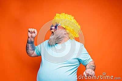 Fat man with beard, tattoos and sunglasses sings a song Stock Photo