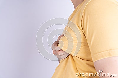 Fat man holding excessive fat boobs isolated grey background Stock Photo