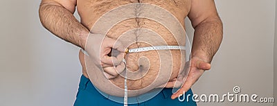 fat man measures the size of the abdomen with a centimeter measuring tape. person is overweight, he is obese. Stock Photo