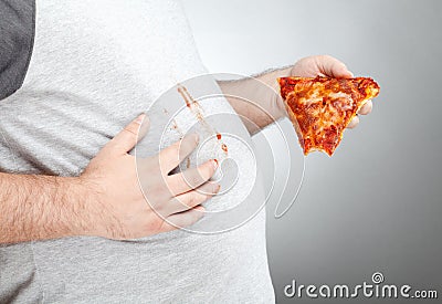 Fat man wiping pizza sauce on his shirt Stock Photo