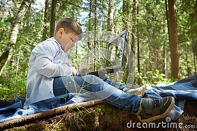A fat teenage boy in the park with a laptop. Gamer, streamer, blogger, sociopathic programmer working alone in the Stock Photo