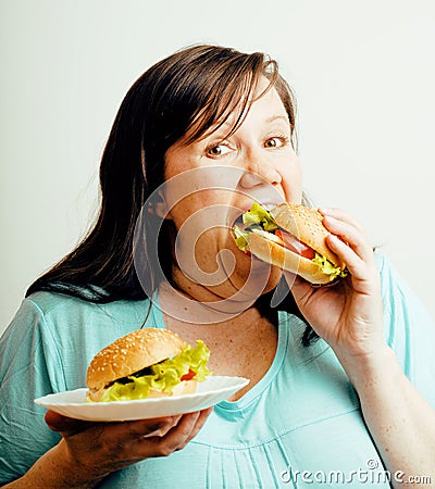 Fat white woman having choice between hamburger and salad, eating emotional unhealthy food, lifestyle people concept Stock Photo