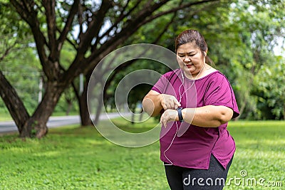 Fat woman asian checking time or heart rate from smart watch. Stock Photo