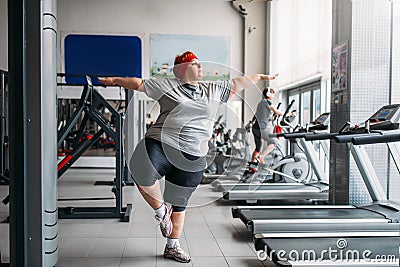 Fat woman doing balance exercise in gym Stock Photo