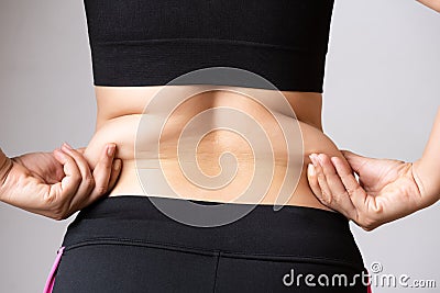 Fat woman hand holding excessive belly fat. Healthcare and woman diet lifestyle concept to reduce belly and shape up healthy Stock Photo