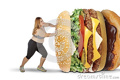 Fat woman pushing tasty foods on studio Stock Photo