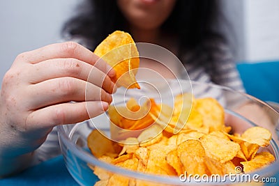 Fat woman reaching to chips. Unhealthy eating, bad habits, food Stock Photo