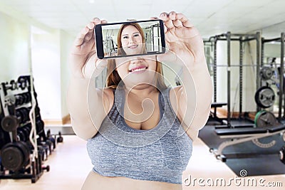 Fat woman takes selfie picture at gym Stock Photo