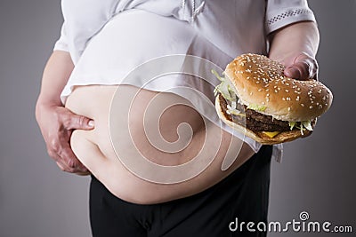 Fat women suffer from obesity with big hamburger in hand, junk food concept Stock Photo