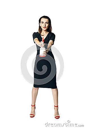 The fatal woman in a black dress with a spray for washing glasses pretending to be a secret agent Stock Photo