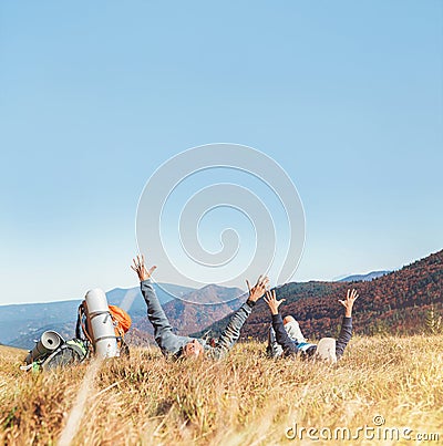 Father and aon backpackers hikers lie with hands up Stock Photo