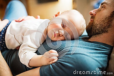 Father with a baby girl at home sleeping. Stock Photo