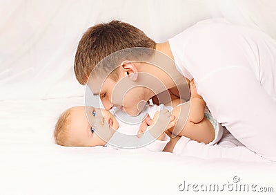 Father and baby at home lying on bed together bedtime Stock Photo