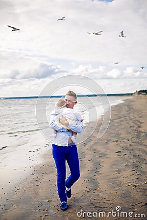 Father in the blue dress nautical throws his little daughter Stock Photo