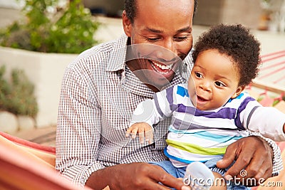 Father bonding with young son sitting in a hammock Stock Photo