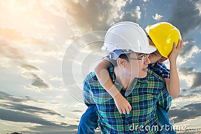 Father builder carrying his son in golden sky cloud and family boding future concept Stock Photo