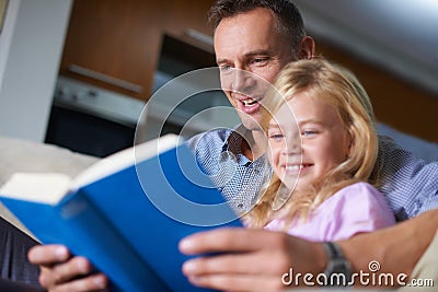 Father, child and reading a book for education at home, story and fantasy fiction for homeschooling. Daddy, daughter and Stock Photo