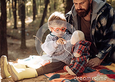 Cute boy with nose wiper near autumn tree. Father and child son in autumn park having fun and laughing. Happy family Stock Photo