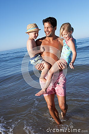 Father And Children Having Fun On Beach Stock Photo