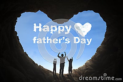 Father and children lifting hands in cave Stock Photo