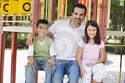 Father with children in playground Stock Photo