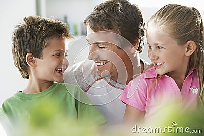 Father With Children Smiling At Home Stock Photo