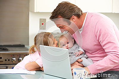 Father with children using laptop in kitchen Stock Photo