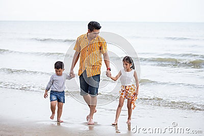 Father And Children walking On Beach Holiday . two kids one dad Stock Photo