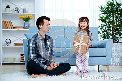 Father and daughter or brother and sister with a gift in the interior of the room. Father`s day holiday concept, Children`s Day Stock Photo