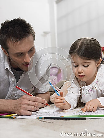 Father And Daughter Coloring Book On Floor Stock Photo