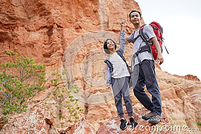 Father and daughter hiking climbing in mountains Stock Photo