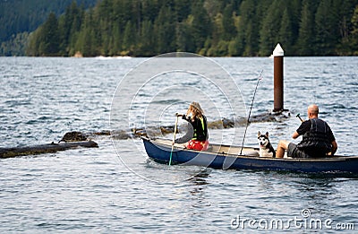 Father and daughter in life jackets and husky dog rowing in boat on the troubled Merwin Lake Editorial Stock Photo