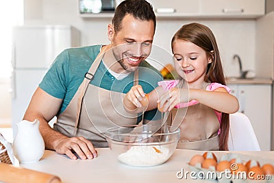 Father And Daughter Making Dough Baking Cake In Kitchen Stock Photo