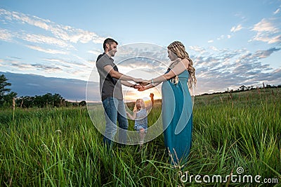 Father, daughter and mother walking outdoors Stock Photo