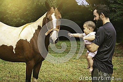 Father and daughter next to a horse Stock Photo