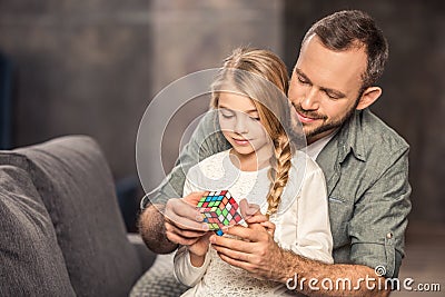 Father and daughter playing with cube Editorial Stock Photo