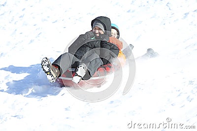 Father and daughter playing in snow sledding, New England, US Editorial Stock Photo