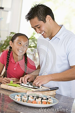 Father And Daughter Preparing Sushi Together Stock Photo