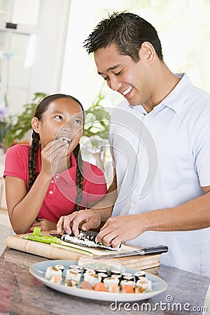 Father And Daughter Preparing Sushi Together Stock Photo