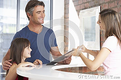 Father With Daughter At Reception Of Dentist's Surgery Stock Photo