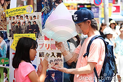 Father and daughter sharing a giant rainbow cotton candy in Harajuku Tokyo Editorial Stock Photo