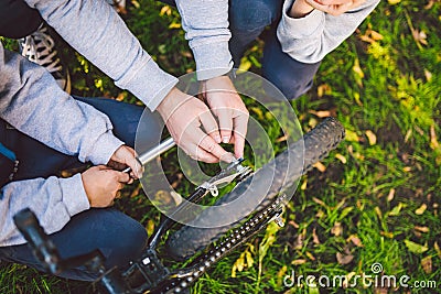 Father day. A large friendly family father and sons together actively relax in the fresh air. Dad teaches sons to repair bicycles Stock Photo