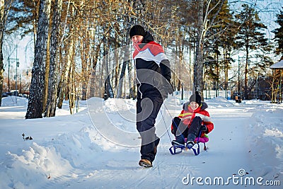 Father drag his boy in sled Stock Photo