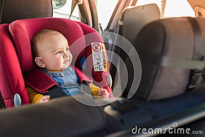 Father fasten his baby in car seat Stock Photo