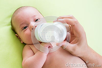 Father feeding his baby infant from bottle Stock Photo
