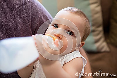 Father feeding milk to baby girl Stock Photo