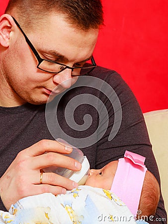 Father feeding newborn baby girl with milk bottle Stock Photo