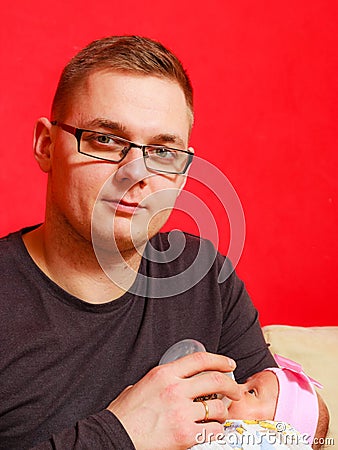 Father feeding newborn baby girl with milk bottle Stock Photo