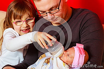 Father feeding newborn baby girl with milk bottle Stock Photo