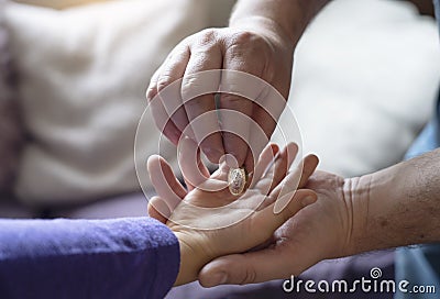 Father giving one pound coin to his son, Crop view of children man hand putting mony coinon kid hand.Parent give money to child Stock Photo